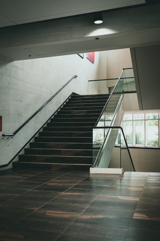 Spacious indoor staircase featuring sleek glass and metal design, ideal for contemporary architecture themes.