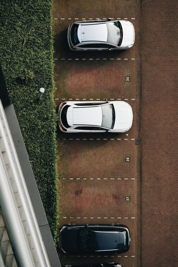 Aerial shot of several cars parked in an outdoor parking lot.